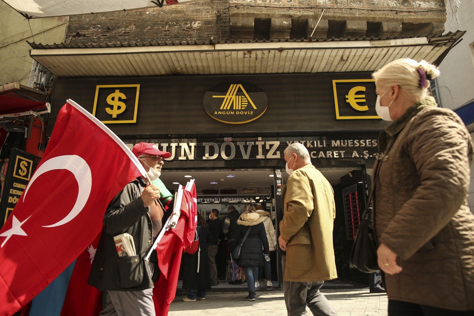 Продавач на турски знамена минава покрай валутно бюро в Истанбул