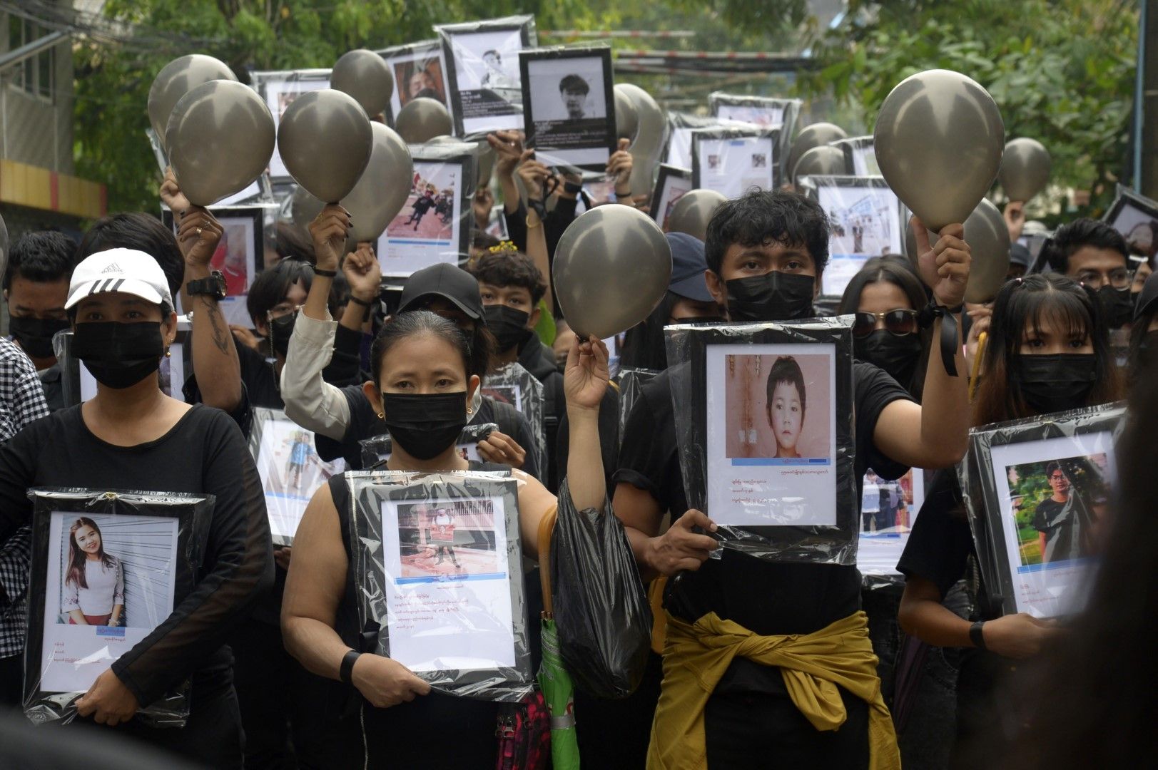 Протестиращи държат снимки на загинали при демонстрациите в Янгон, Мианма, срещу военния режим