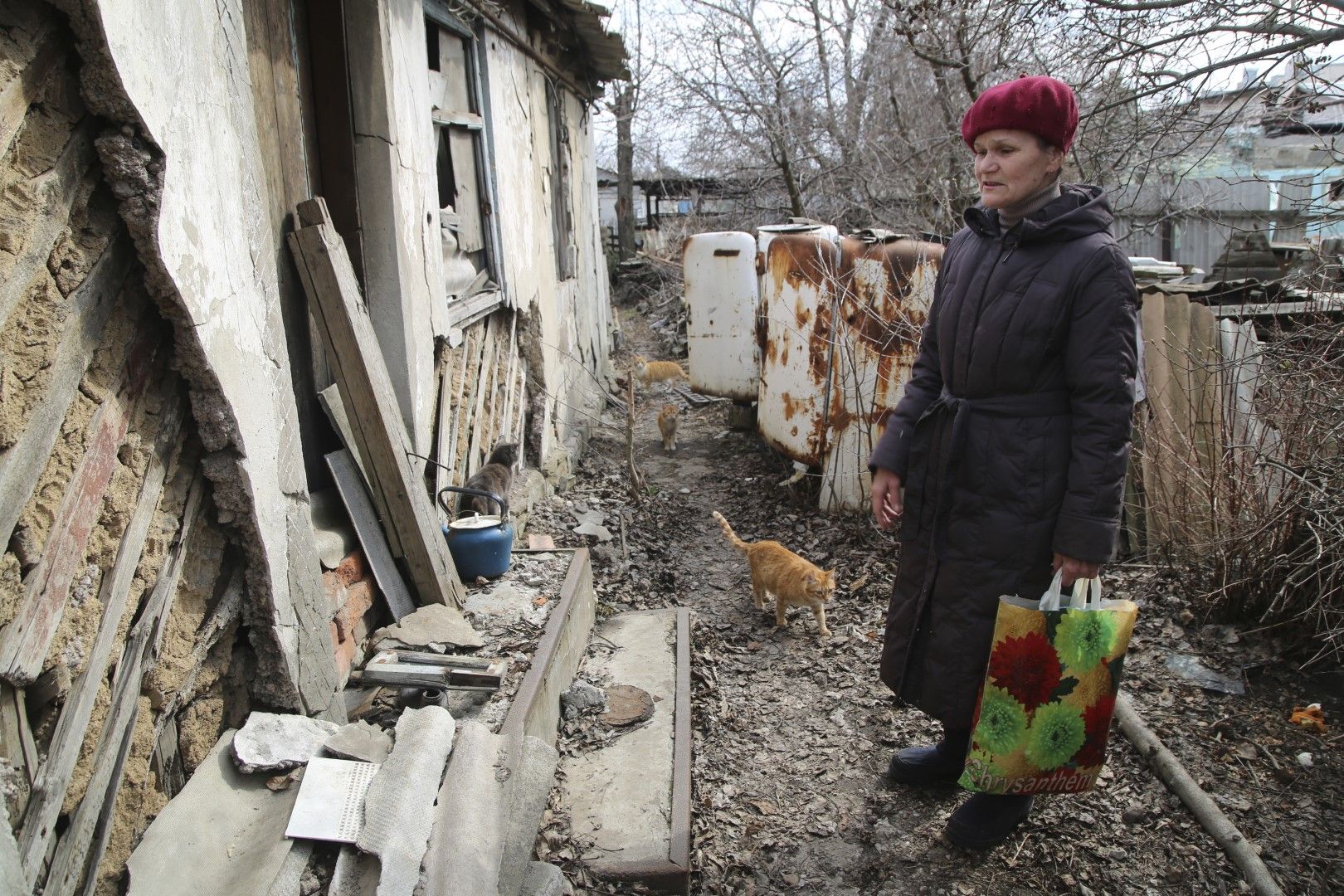 Жена се прибира в дома си в контролирана от сепаратистите територия, за да събере вещите си след неотдавнашен обстрел близо до фронтовата линия край Донецк, Източна Украйна, петък, 9 април 2021 г. 