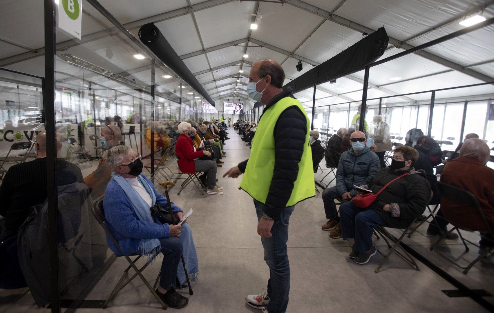 Ваксинационно селище в Антверпен, Белгия. Служебно лице разговаря с граждани, току-що получили доза от ваксината на Модерна