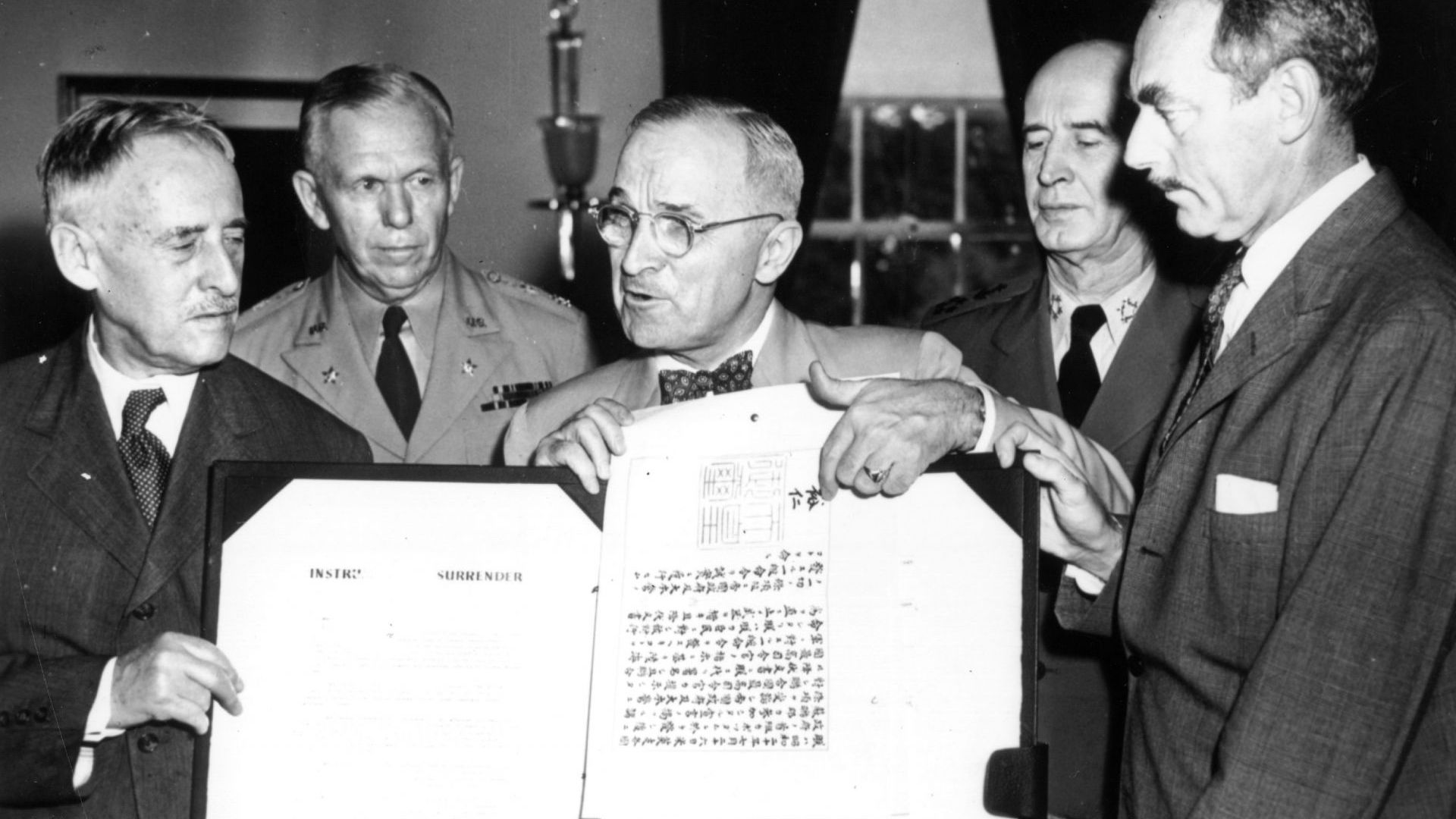  Президентът Хари Труман държи формалния японски документ за капитулация, подписан от император Хирохито 