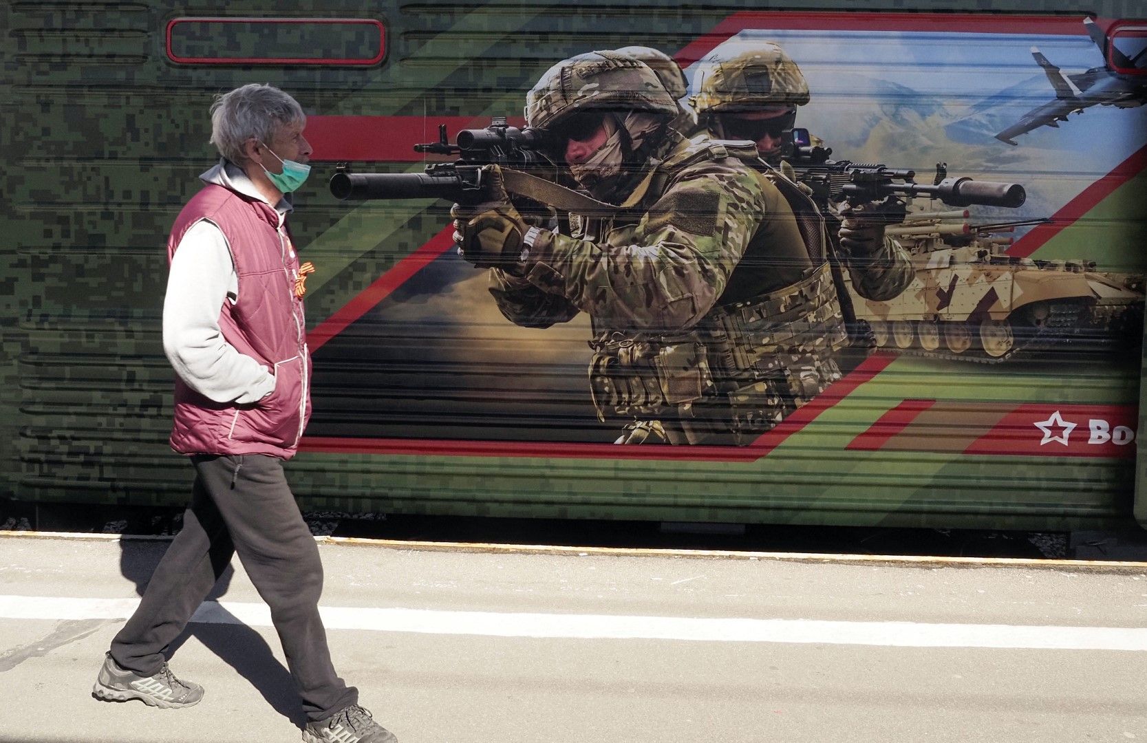 Пешеходец минава покрай военен плакат на жп гара в Санкт Петербург. В резолюцията си евродепутатите заявяват, че ако Русия нахлуе в Украйна, Москва трябва да бъде изключена от платежната система SWIFT, вносът в ЕС на руски енергоносители да бъде прекратен