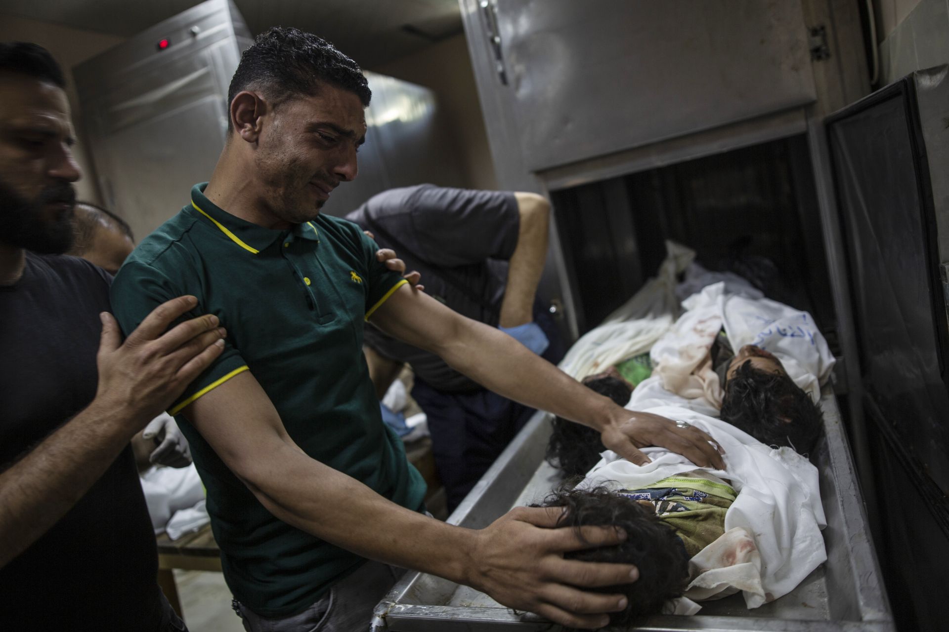 Палестински роднина скърби над телата на четирима млади братя , открити под развалините на разрушена къща след израелски въздушни удари в Бейт Лахия, Северна ивица Газа