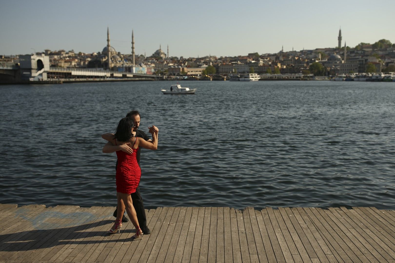 Двойка танцува на фона на залива Златния рог, водещ до Босфорския проток, разделящ Европа и Азия, в Истанбул, петък, 14 май 2021 г. 