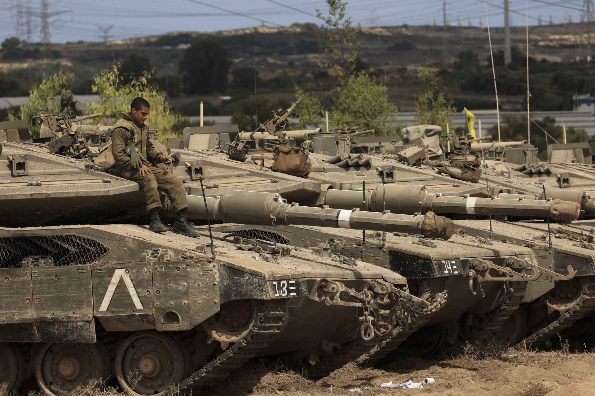 Израелски войник седи върху танк, недалеч от границата с Ивицата Газа