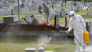 Здравни работници в Малайзия облечени в цели предпазни костюми извършват