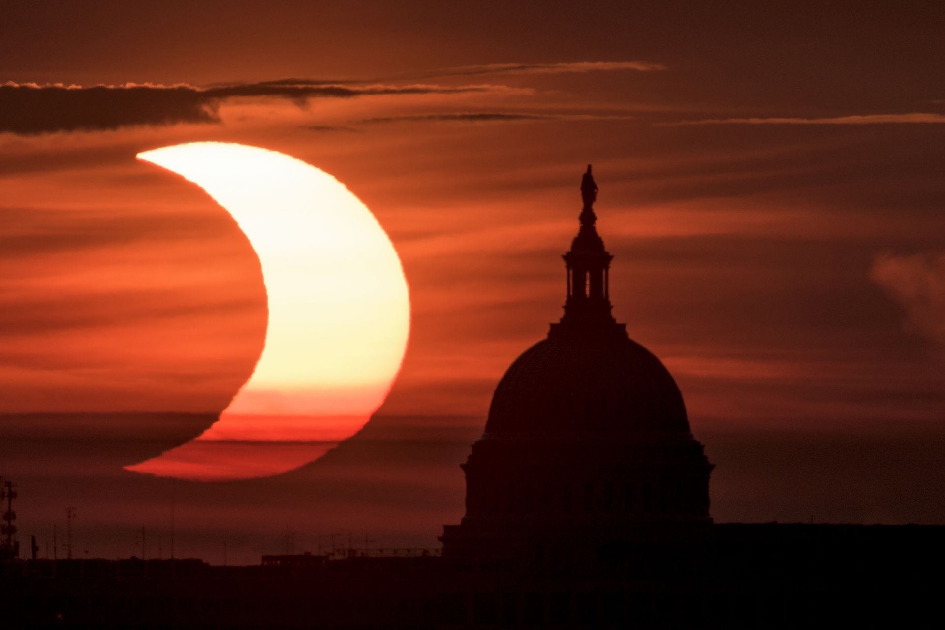 На тази снимка, предоставена от НАСА, се вижда частично слънчево затъмнение, когато слънцето изгрява вляво от Капитолия на САЩ във Вашингтон, четвъртък, 10 юни 