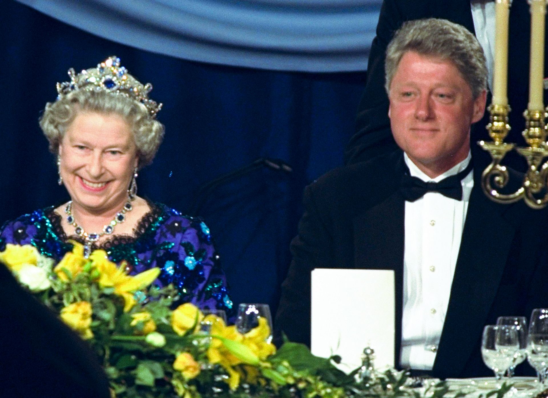 4 юни 1994 г.,  кралица Елизабет се усмихва, докато седи до президента Бил Клинтън на вечеря в Гилдхол в Портсмут