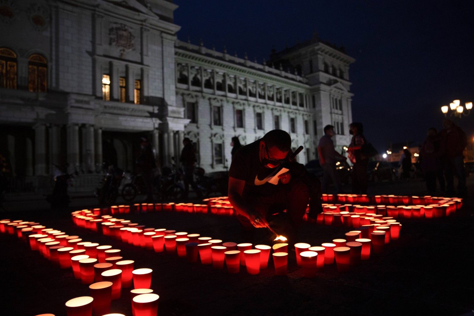 Мъж запалва свещи по време на помен в памет на хилядите хора, загинали от COVID-19 в Гватемала Сити, събота, 26 юни 2021 г.