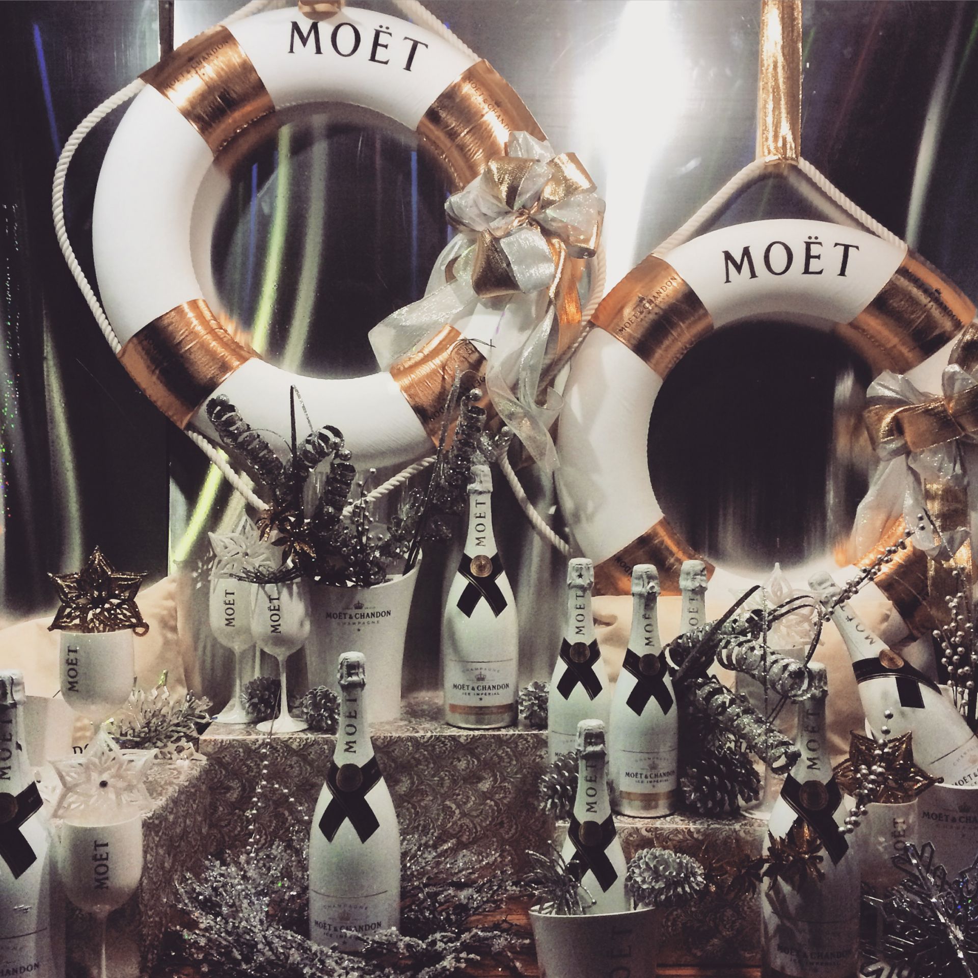 Коледна витрина на винен магазин, украсена с бутилки "Моет"