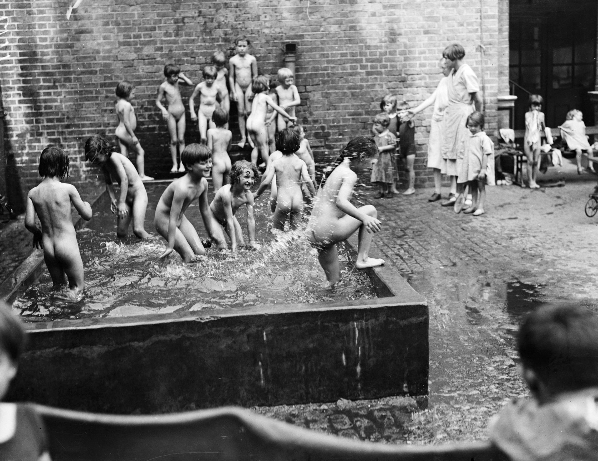 13 август 1932 г.: Децата се охлаждат в басейн по време на лятната жега. 