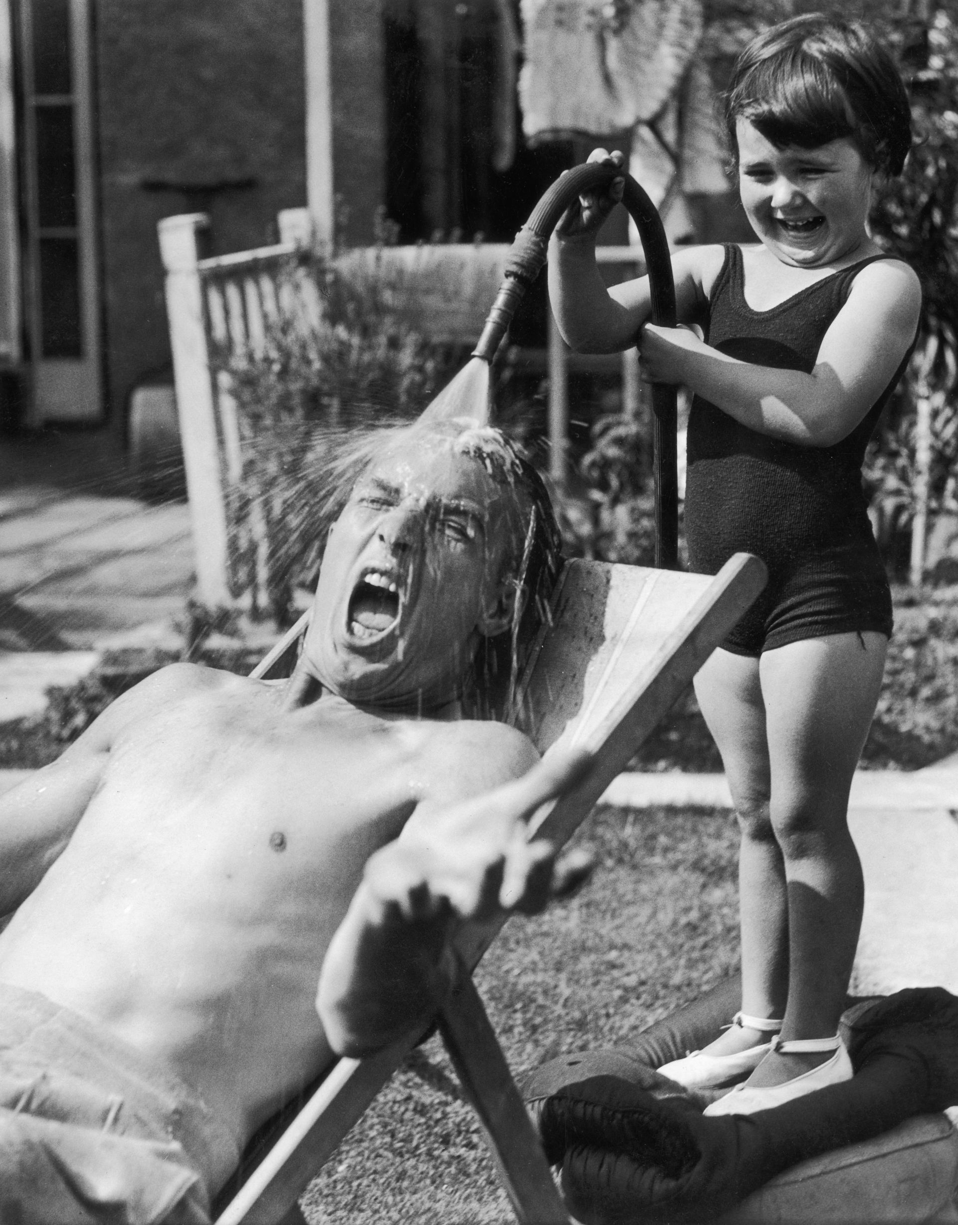 24 август 1936: Малко момиченце се забавлява, докато полива баща си неочаквано (и шокиращо)  със студена вода