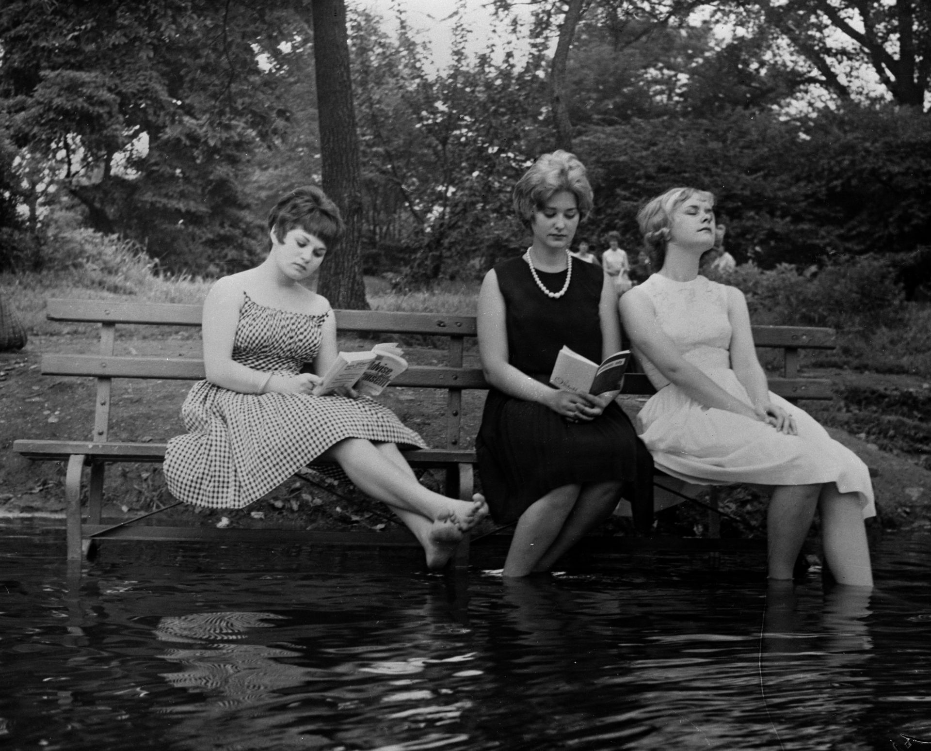 Септември 1961: Три жени се охлаждат по време на гореща вълна, като са преместили пейка в парк във водата в Сентръл Парк, Ню Йорк. 