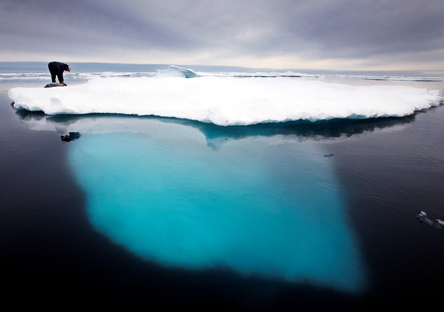 Ловец на тюлени върху айсберг край Гренландия. Автономната датска територия иска да съхрани риболова, туризма и климата