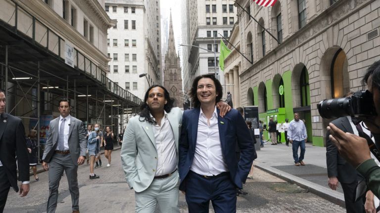 Baiju Bhat put his hand on Vladimir Tenev's shoulder for a photo in front of the New York Stock Exchange after the IPO of their company in Nasdaq on July 29, 2021 in New York