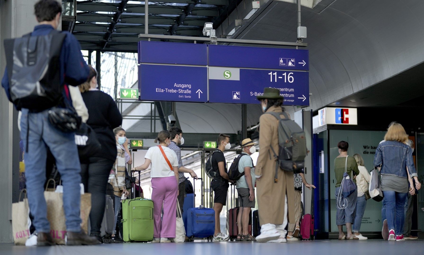 Пътници стоят пред таблото на Дойче бан на гарата в Берлин, 11 август