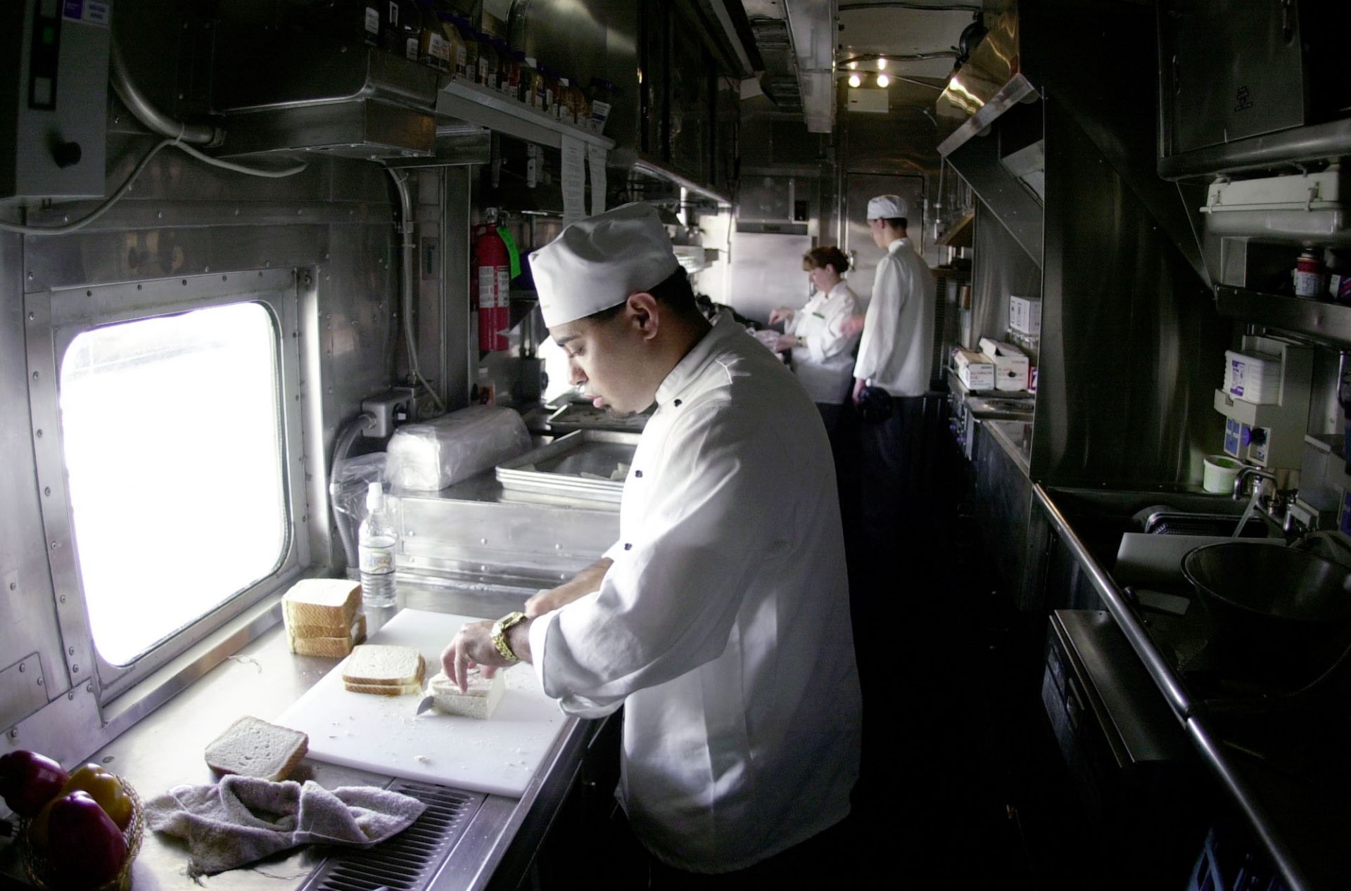 Сервитьор инспектира подредбата на масите във вагон ресторанта, 2000 г.
