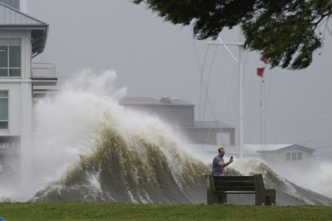 Мъж прави снимки на големите вълни край бреговете на Ню Орлиънс, Луизиана, при връхлитането на урагана Айда в неделя