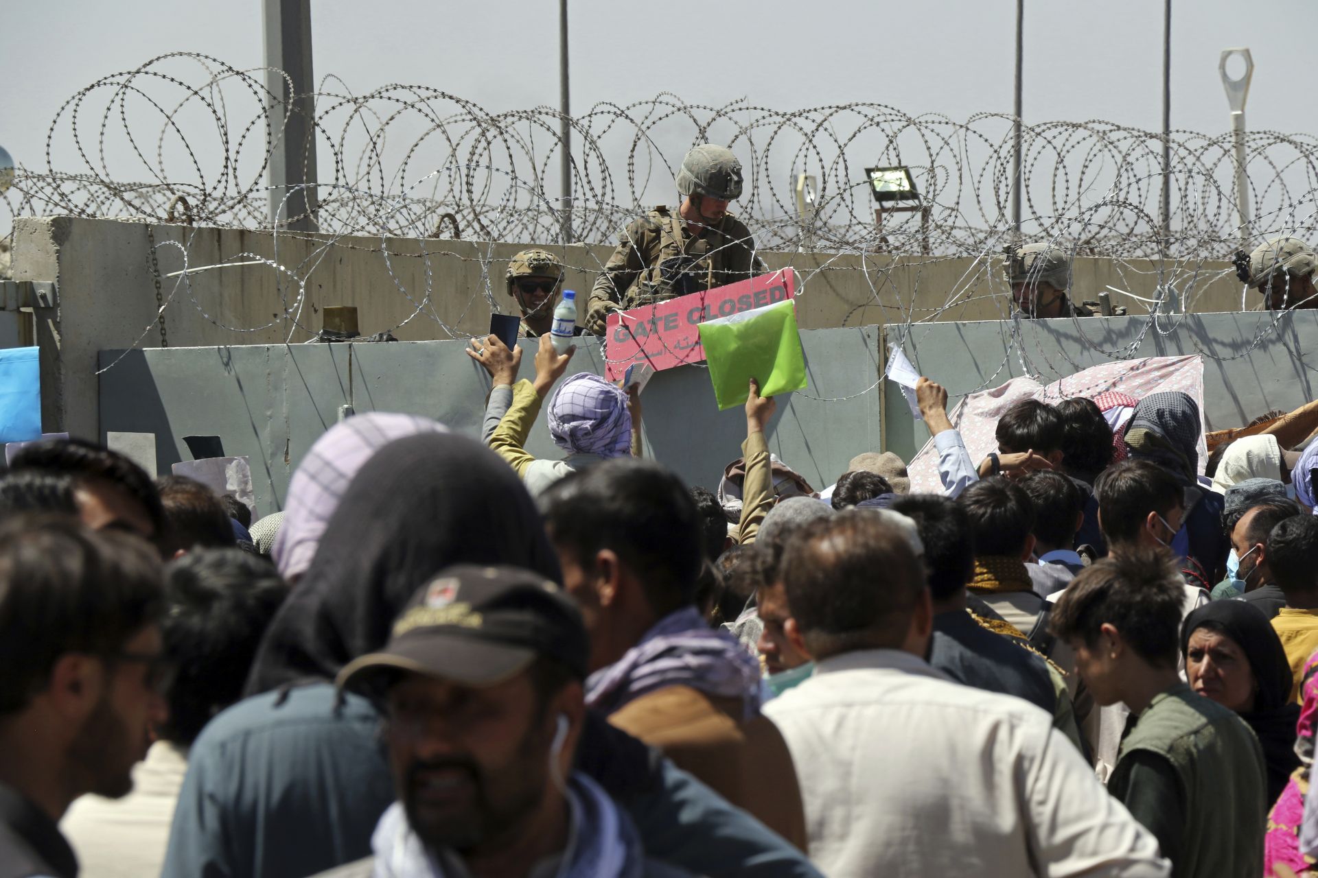 Американски войник държи надпис, на който пише входът е затворен, с което показва, че към момента няма достъп на афганистанците до летището в Кабул, 26 август