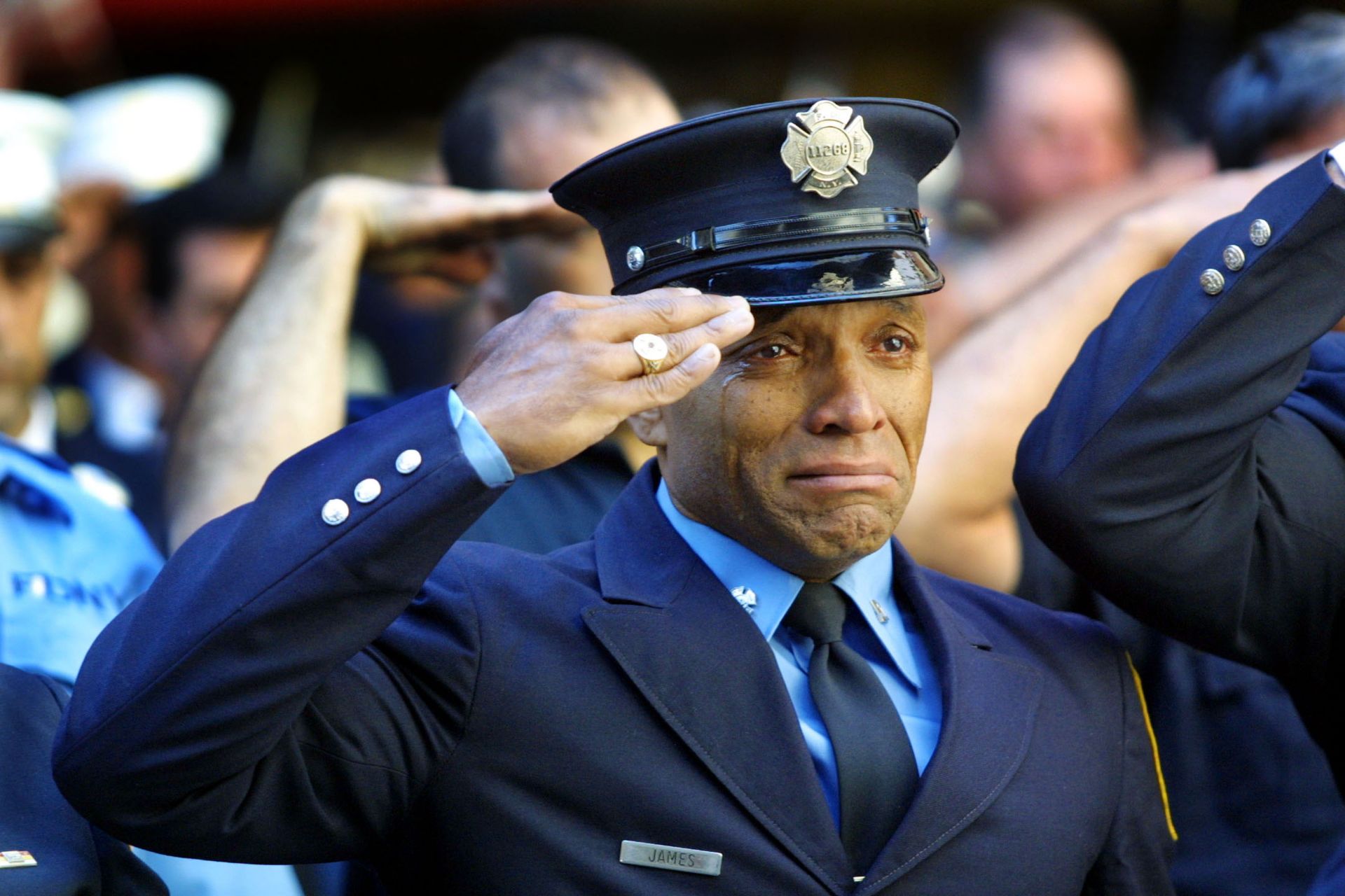 Пожарникарят Тони Джеймс плаче, докато присъства на погребална служба