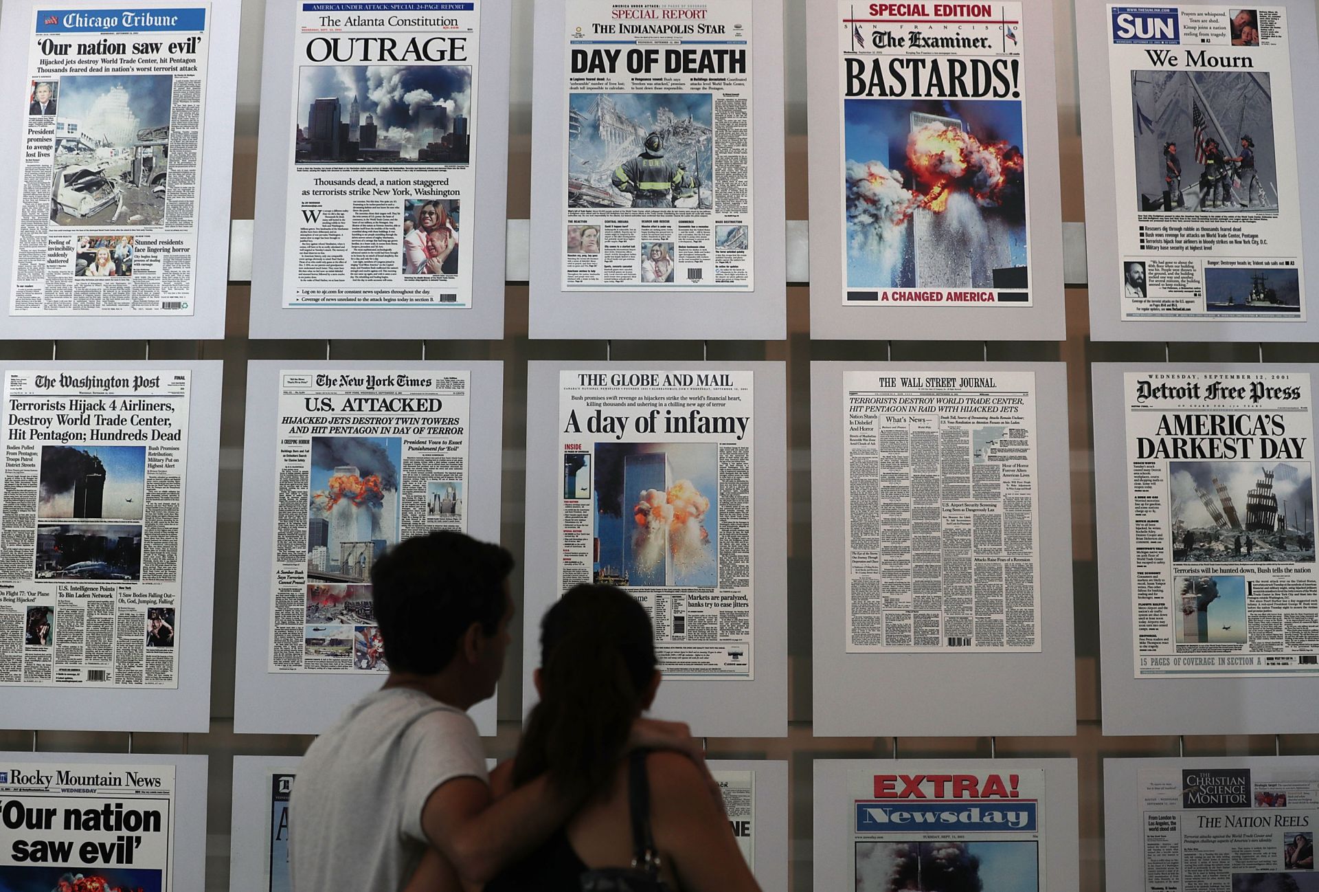 Мъж и жена гледат първите страници на световната преса веднага след атентата