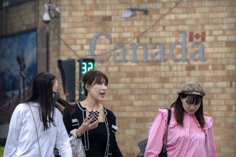 Китайки се разхождат край посолството на Канада в Пекин