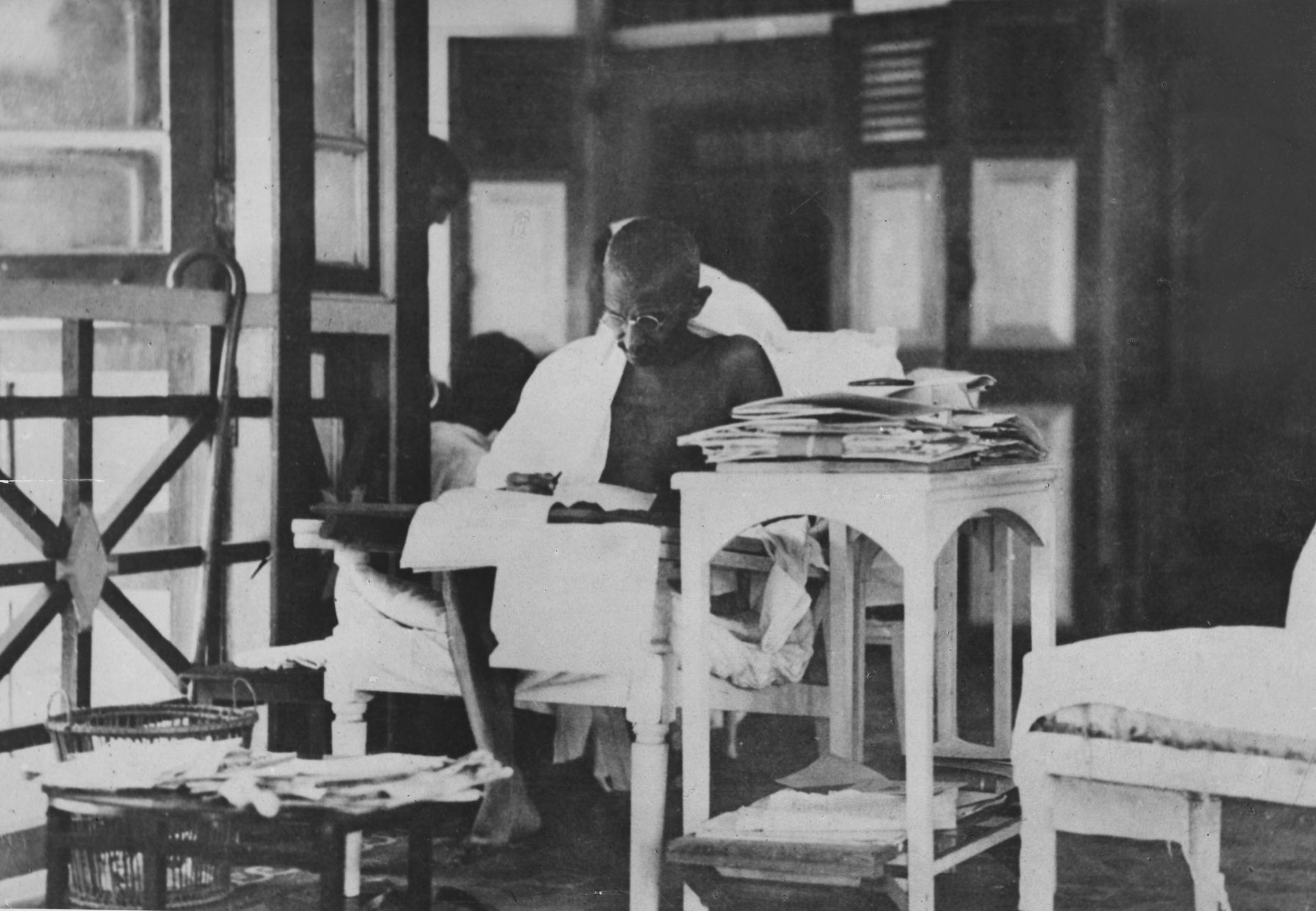 20 май 1924 г .: Махатма Ганди чете кореспонденцията си, докато живее уединено след освобождаването му от затвора