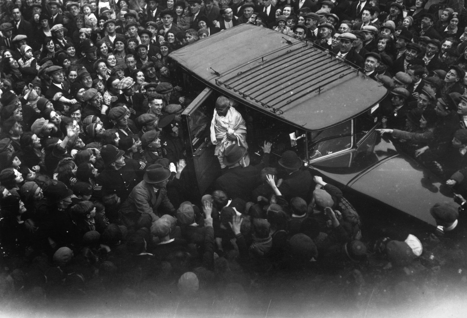  22 септември 1931 г.: Възхитена навалица от Ийст Енд посреща Махатма Ганди в Канинг Таун, Източен Лондон, където ще се срещне с Чарли Чаплин 