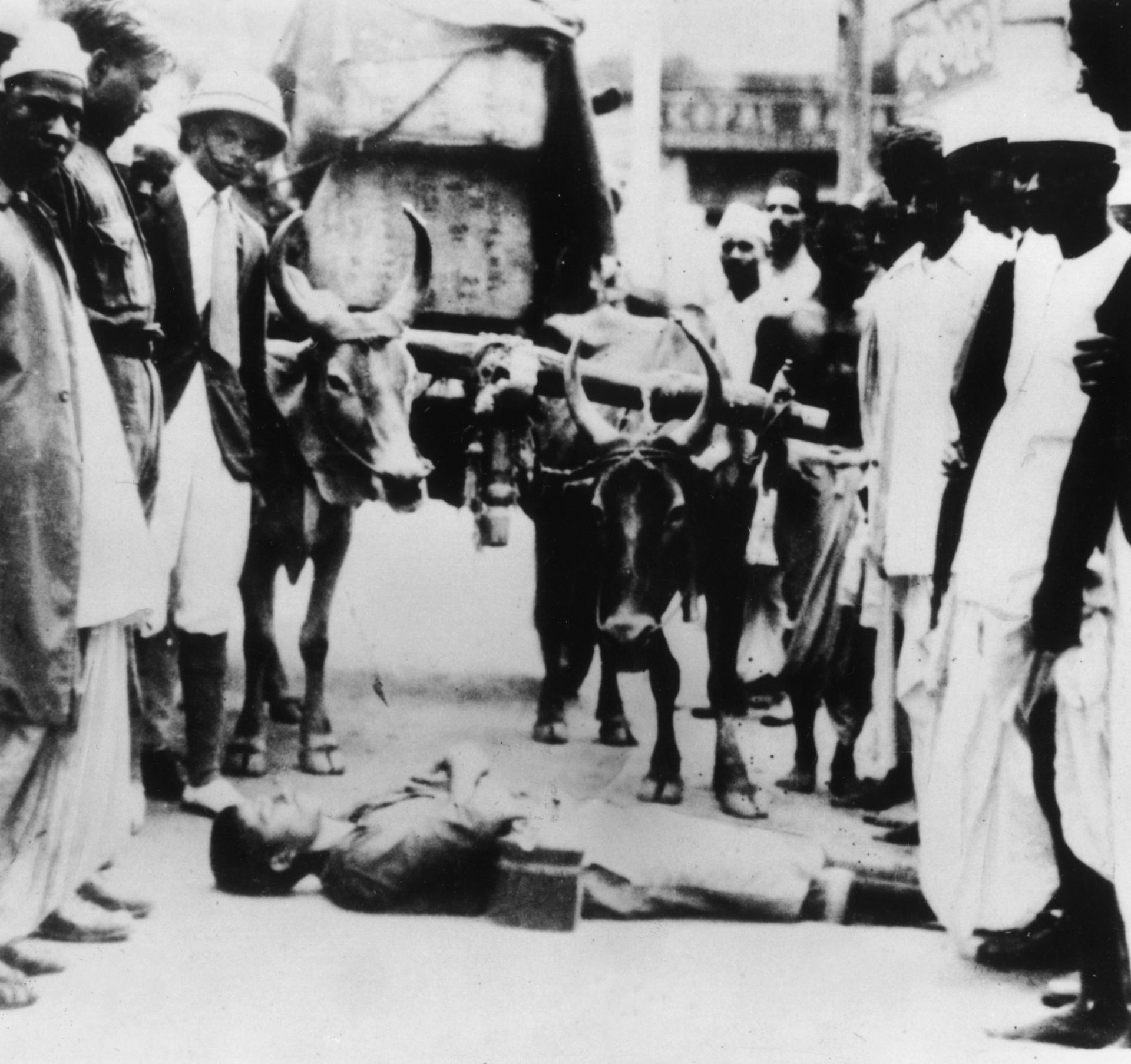  Индийски доброволец лежи пред каруца от импортирани английски облекла, които се транспортират в Бомбай, следвайки метода на мирния митинг на Ганди 