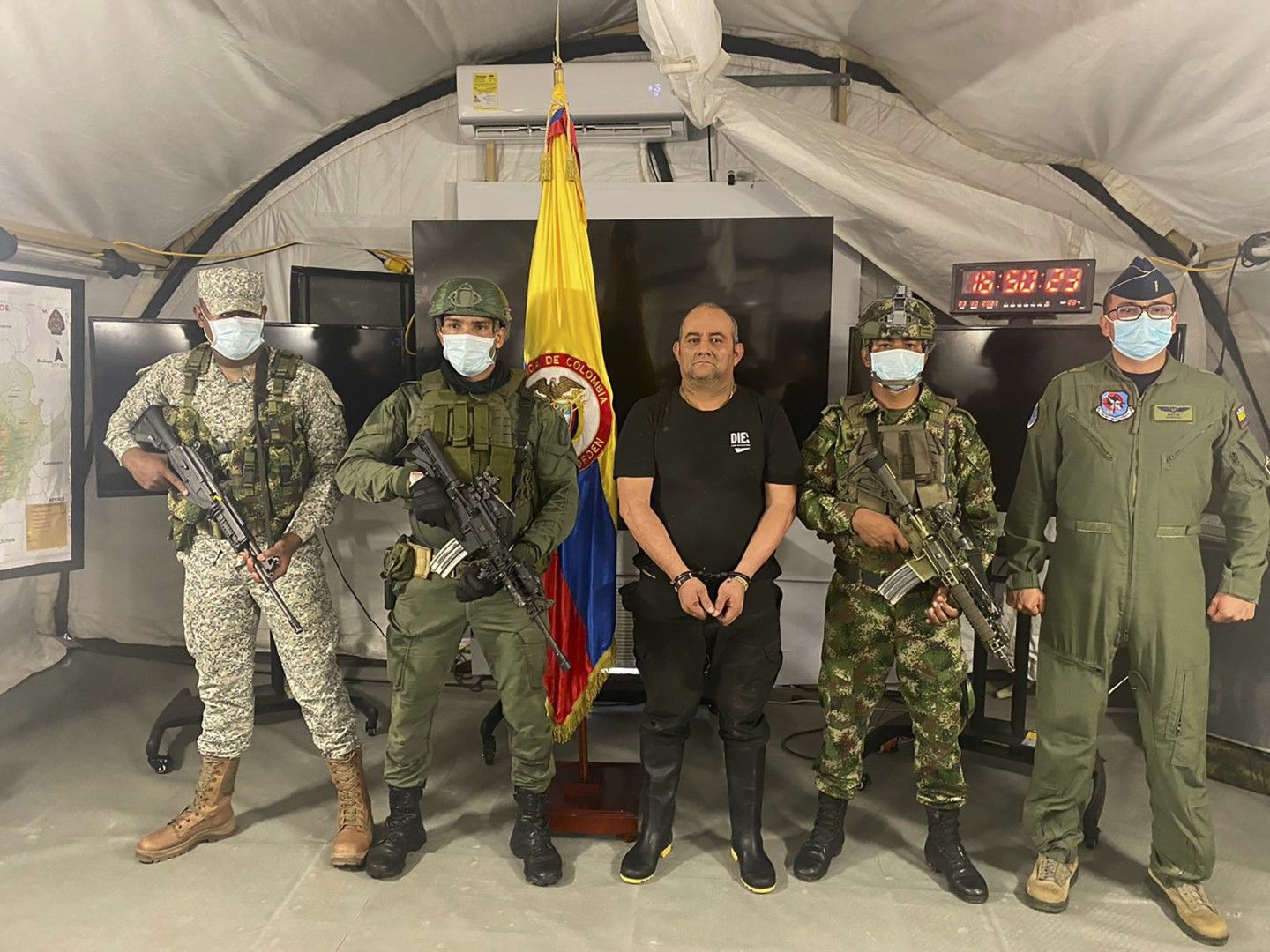 На тази снимка, осигурена от президентството на Колумбия наркотрафикантът Дайро Антонио Усуга е сред военни, които са участвали в залавянето му