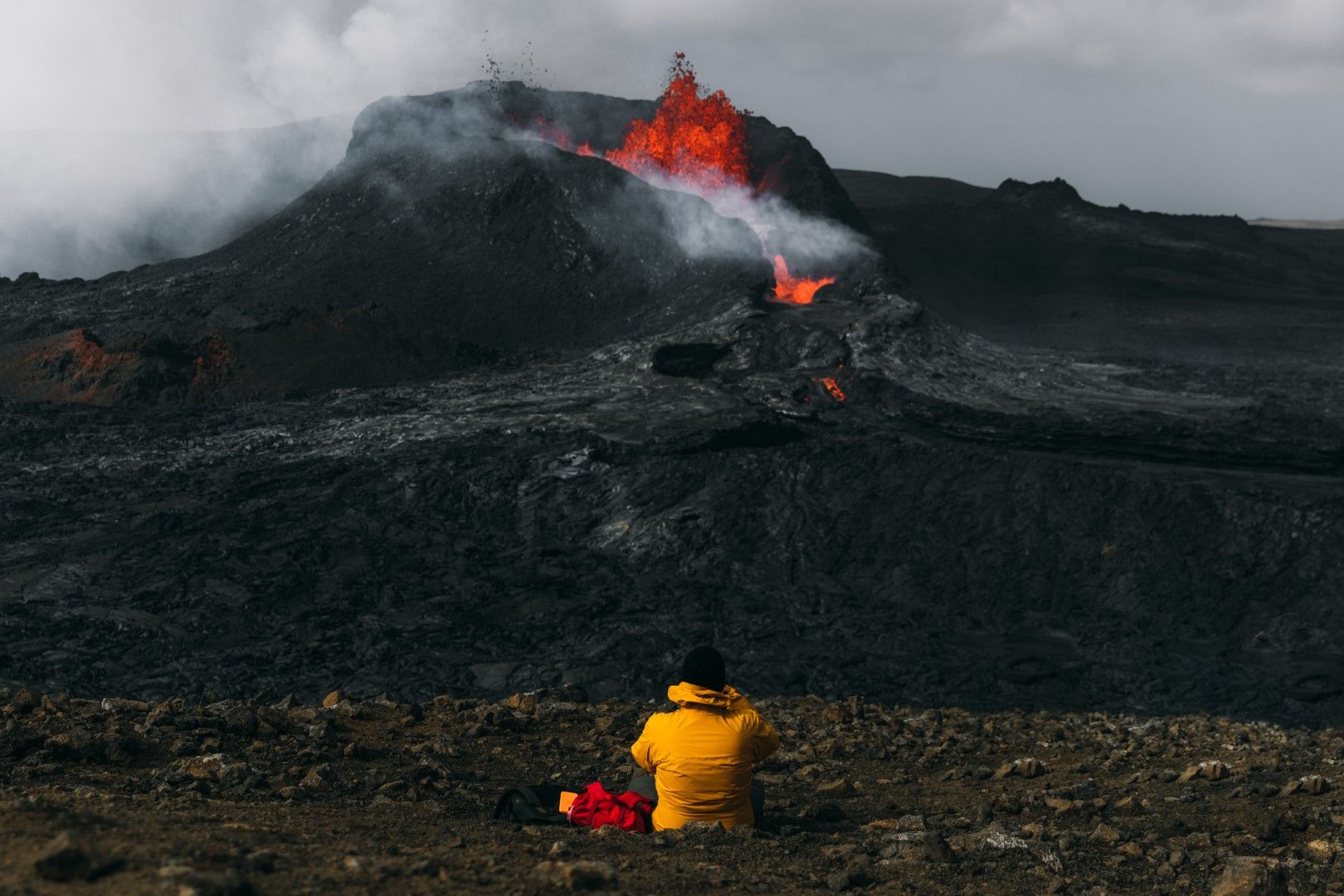 Турист наблюдава изригването на вулкана Фаградалсфядл в Исландия. През последните 6000 години вулканът е бил спящ.