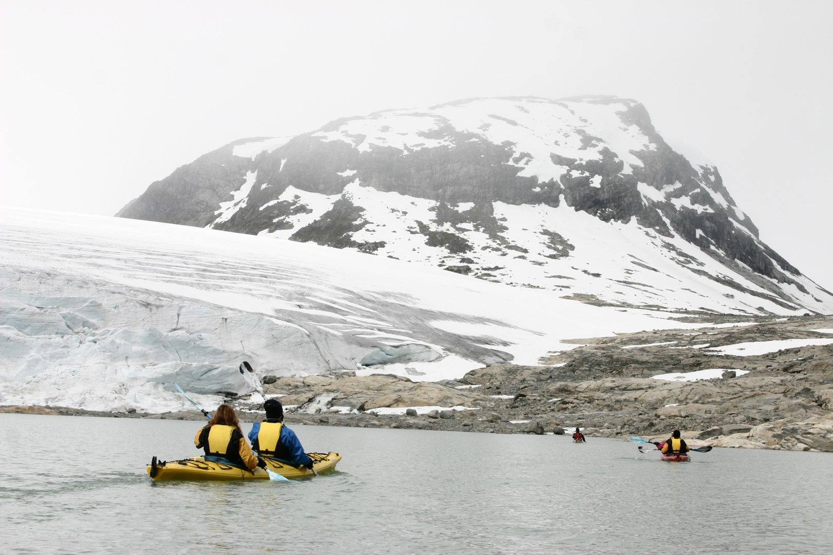 Туристи плават с каяк в езеро под ледника Юстедалсбреен