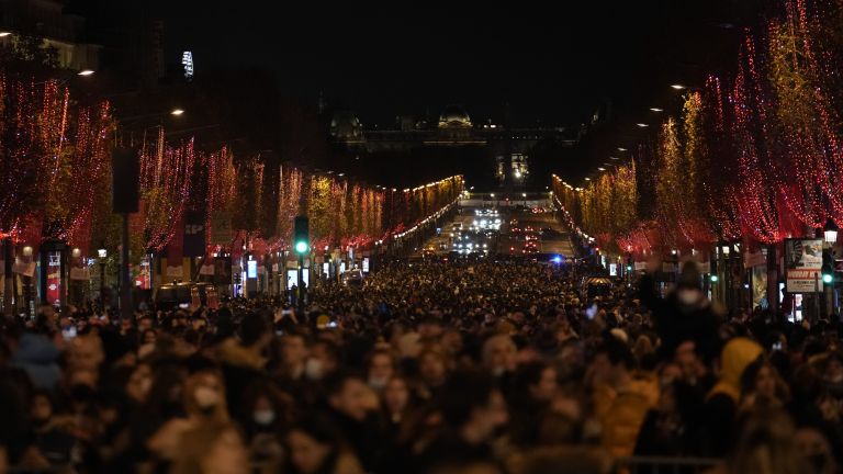 Емблематичният булевард Шанз-Елизе в Париж грейна в коледни червени светлини