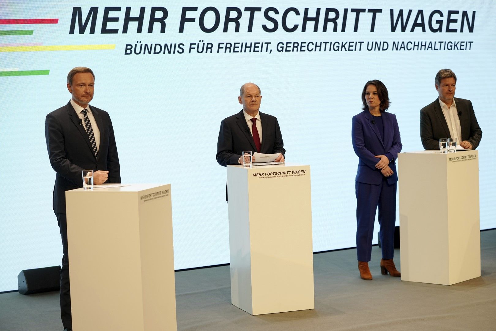 Kандидатът за канцлер Олаф Шолц (ГСДП), втори вляво, заедно  с лидерите на Зелената партия Аналена Бербок, трета отляво, Робърт Хабек, вдясно, и председателят на Свободната демократическа партия Кристиан Линднер, вляво, на съвместна пресконференция в Берл