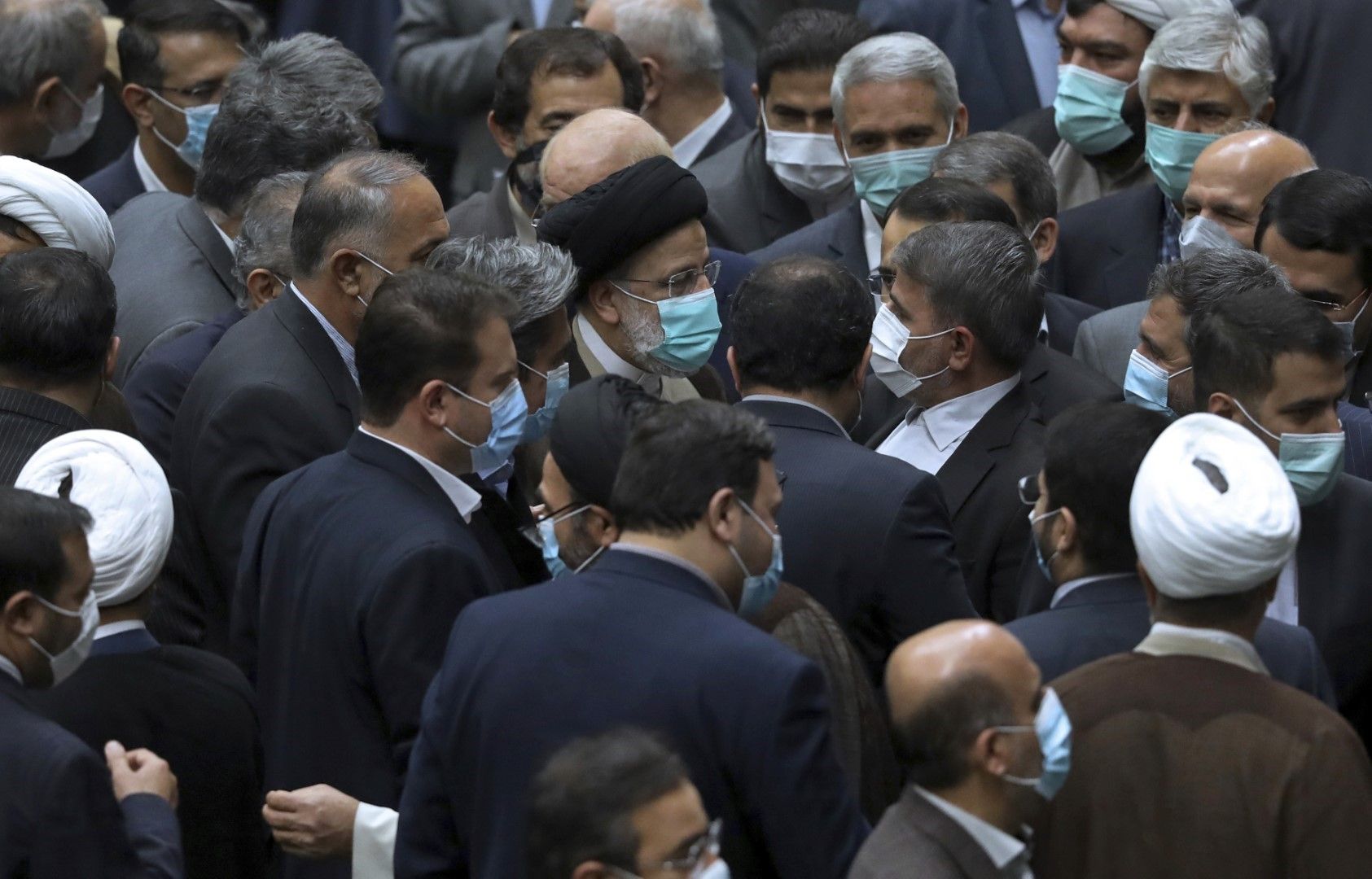 Президентът на Иран Ибрахим Раиси (в средата) заобиколен от депутати в парламента в Техеран