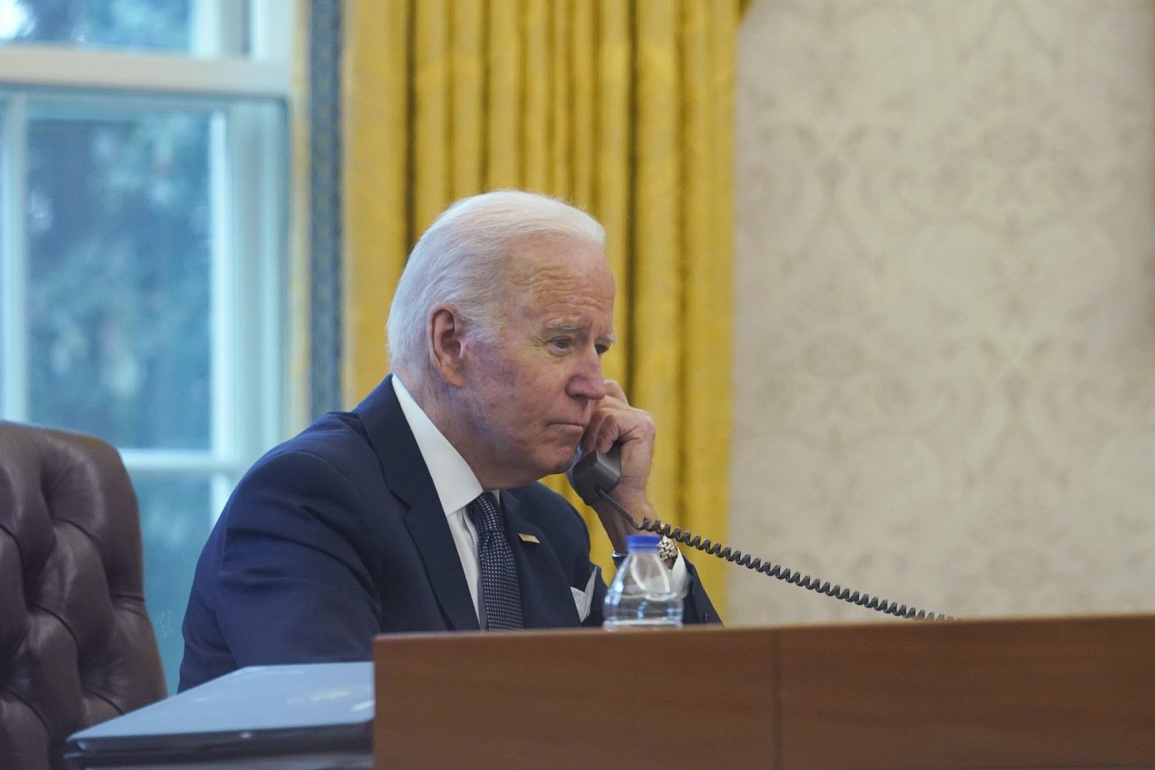 От снимка, направена през прозореца се вижда президентът Джо Байдън по време на разговора му по телефона с украинския президент Володимир Зеленски