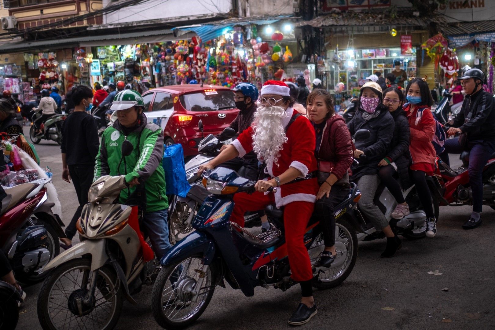 Облечен като Дядо Коледа виетнамец се дивижи в интензивния трафик на столицата Ханой