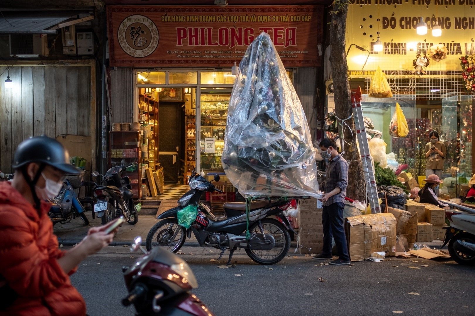 Търговец наглася изкуствена елха за транспорт в Ханой