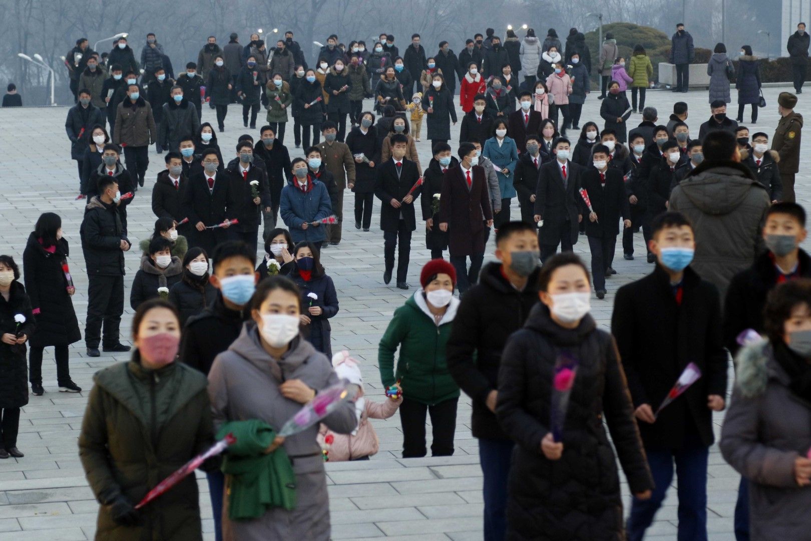 Гражданите се отправят към бронзовите статуи на покойните си лидери Ким Ир Сен и Ким Чен Ир на хълма Мансу в Пхенян, Северна Корея, четвъртък, 16 декември 2021 г.
