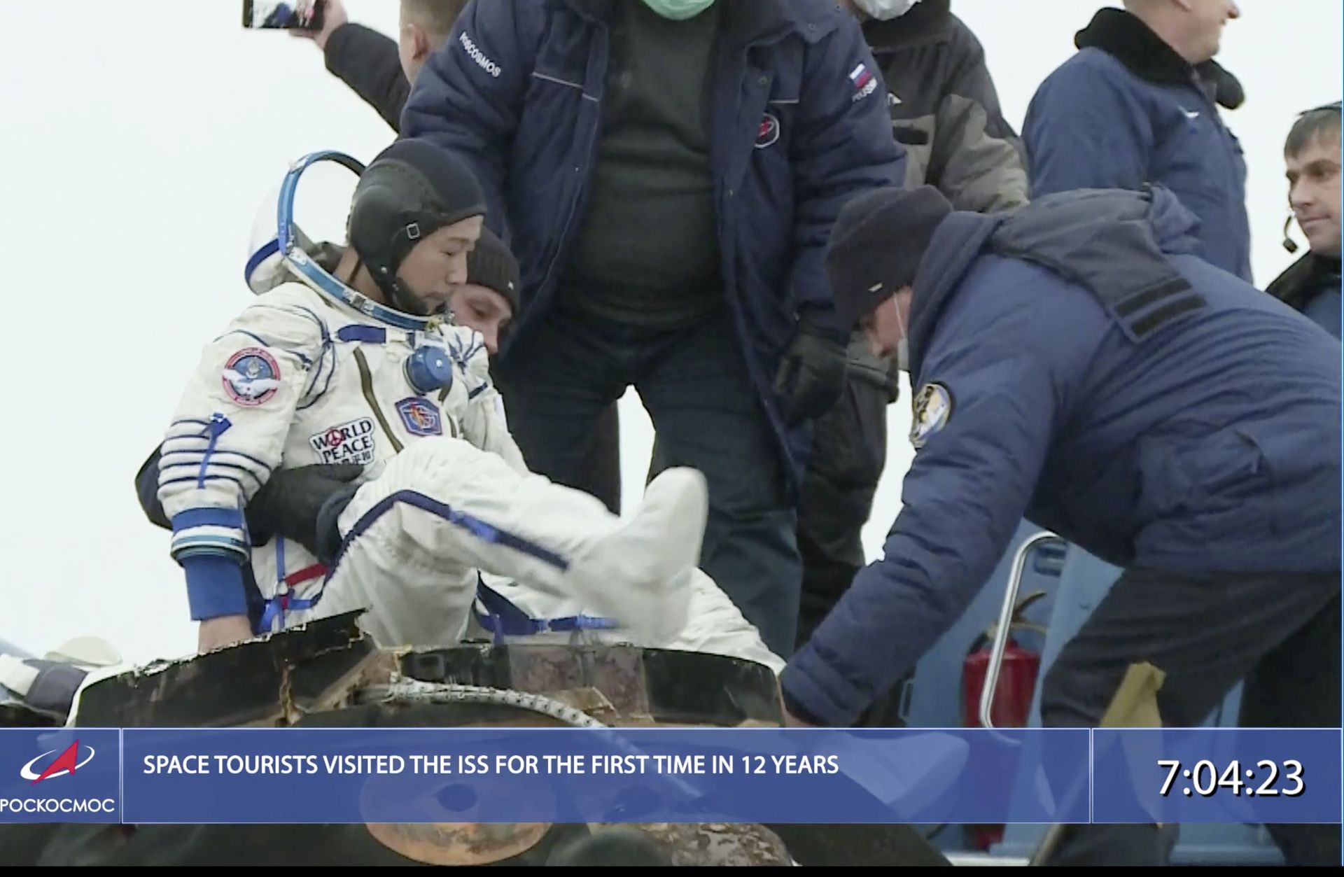 спасителният екип на руската космическа агенция помага на участника в космическия полет Юсаку Маезава да излезе от капсулата малко след кацането