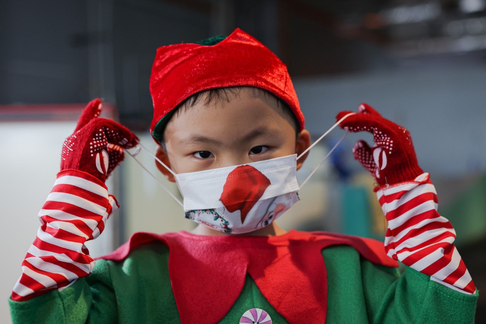 Момче с маска се подготвя да излезе на коледнито ледено шоу в Малайзия.