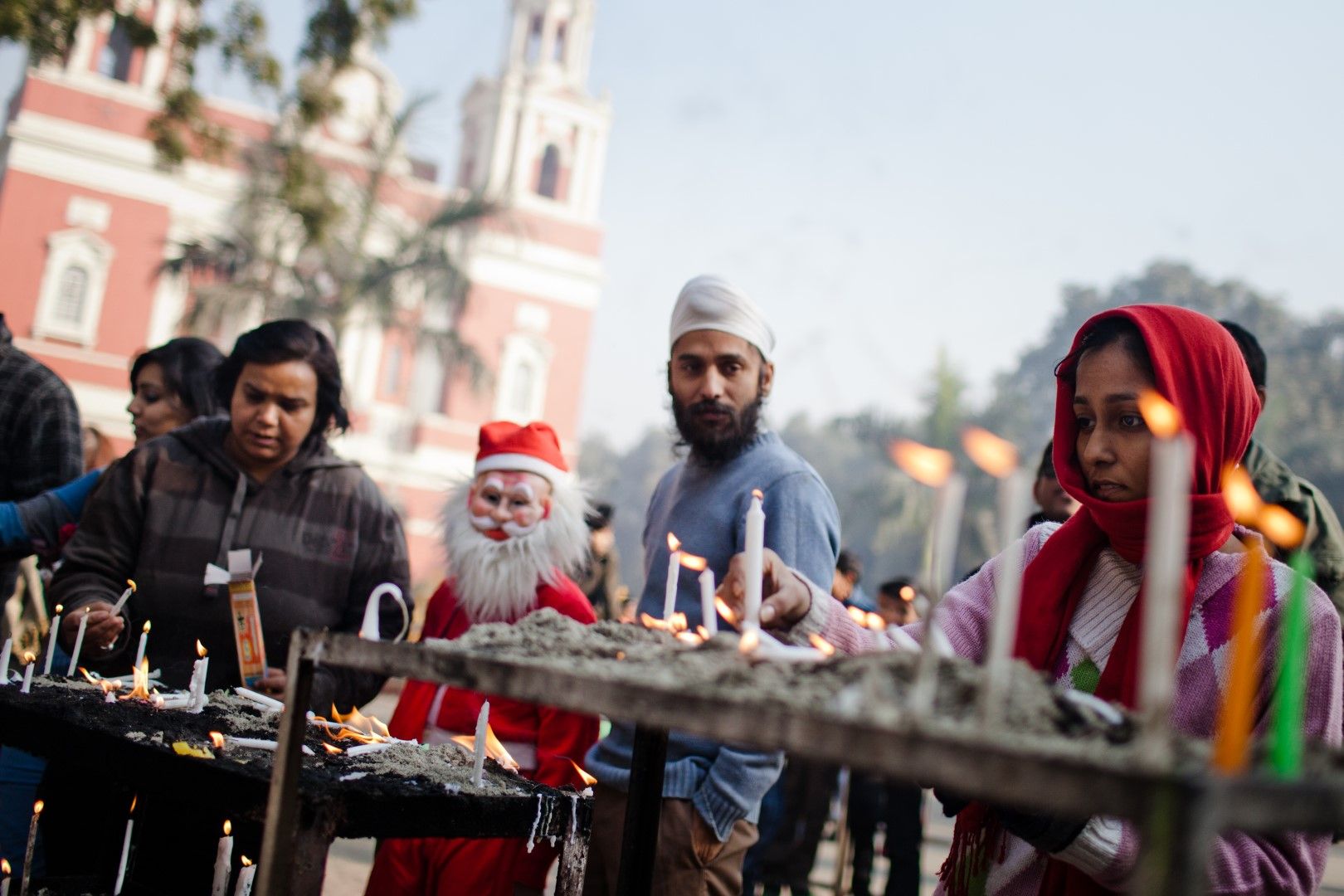 Продавач на свещи пред катедрала в Ню Делхи очаква клиентите си