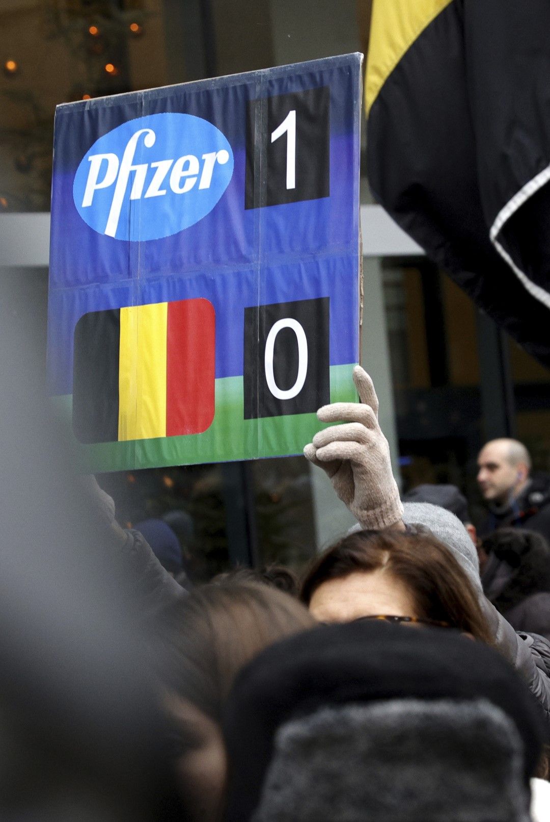 Протестиращ държи плакат с резултат, която показва „Pfizer-1, Белгия-0“ по време на демонстрация срещу ограничителните мерки за COVID-19 в Брюксел, 19 декември 2021 г.