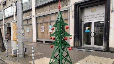 Украсена новогодишна елха която е във формата на електрически стълб