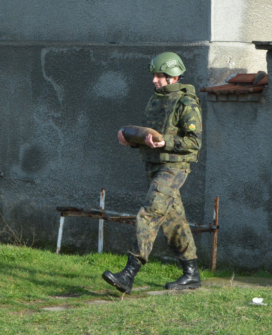  Войник придвижва открития в парцела невзривен снаряд 