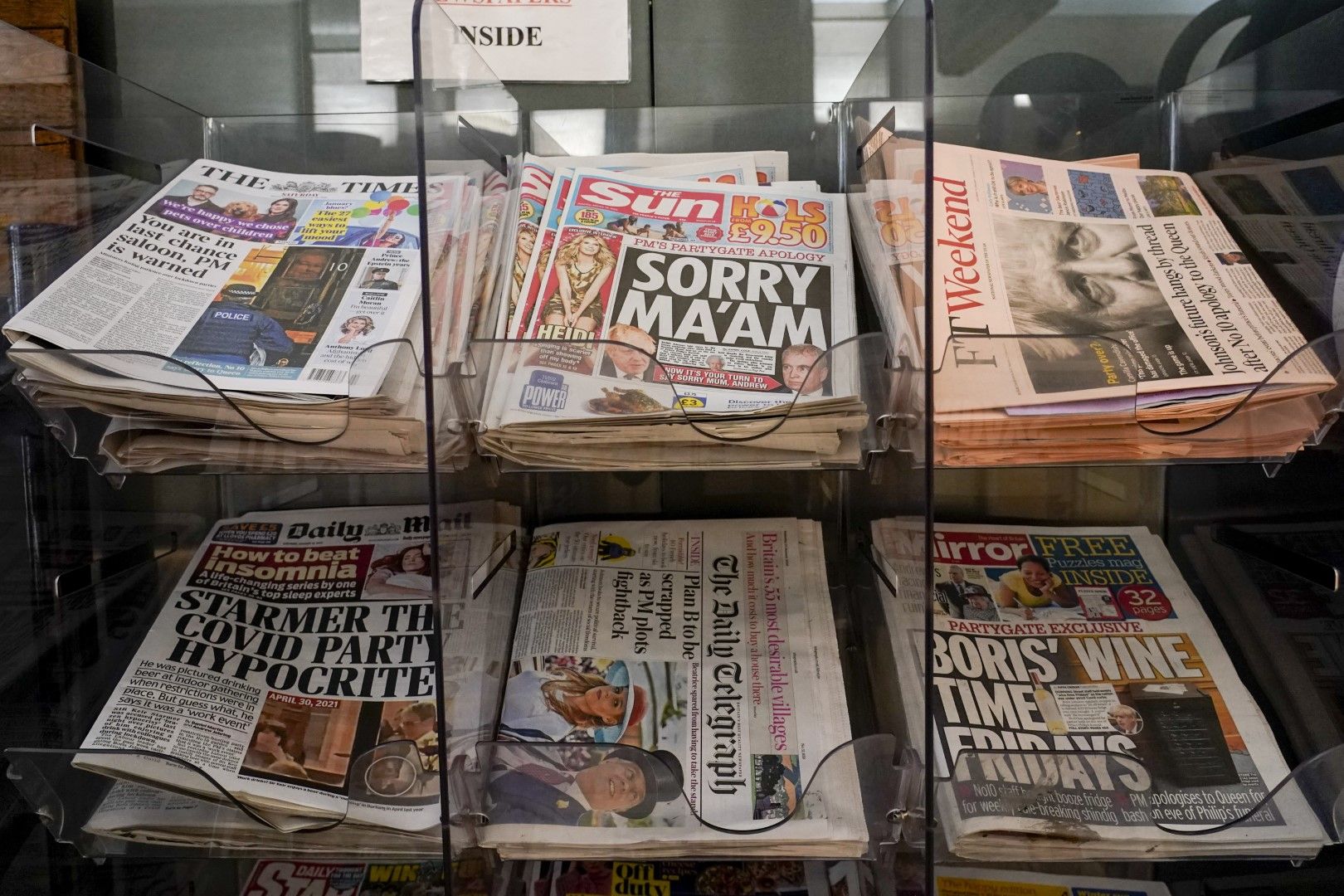 Първите страници на британските вестници, изложени пред будка в Лондон, събота, 15 януари 2022 г. Долу вдясно е заглавието на "Мирър" за петъци за вино на Борис