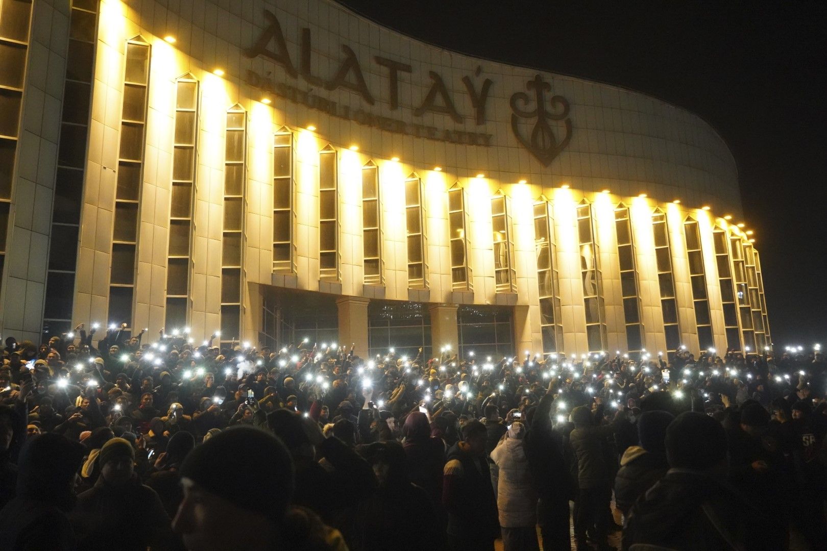 Протестиращи, осветени от смартфоните си, докато се събират в центъра на Алмати, Казахстан, 4 януари 2022 г.