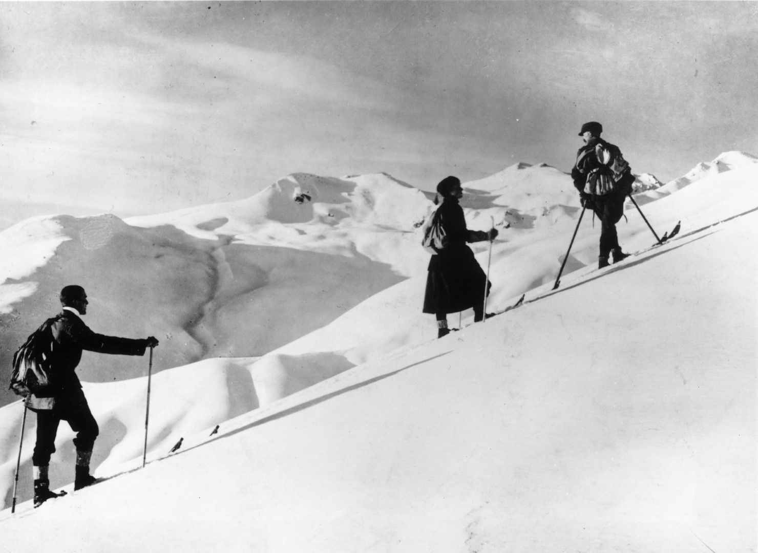 Група скиори се изкачват със ските си по склоновете на Давос, Швейцария, около 1925 г.