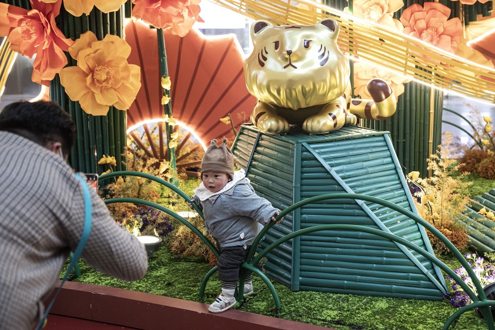 Родители снимат детето си с празничната украса на тема Годината на тигъра в търговски център в Ухан, Китай