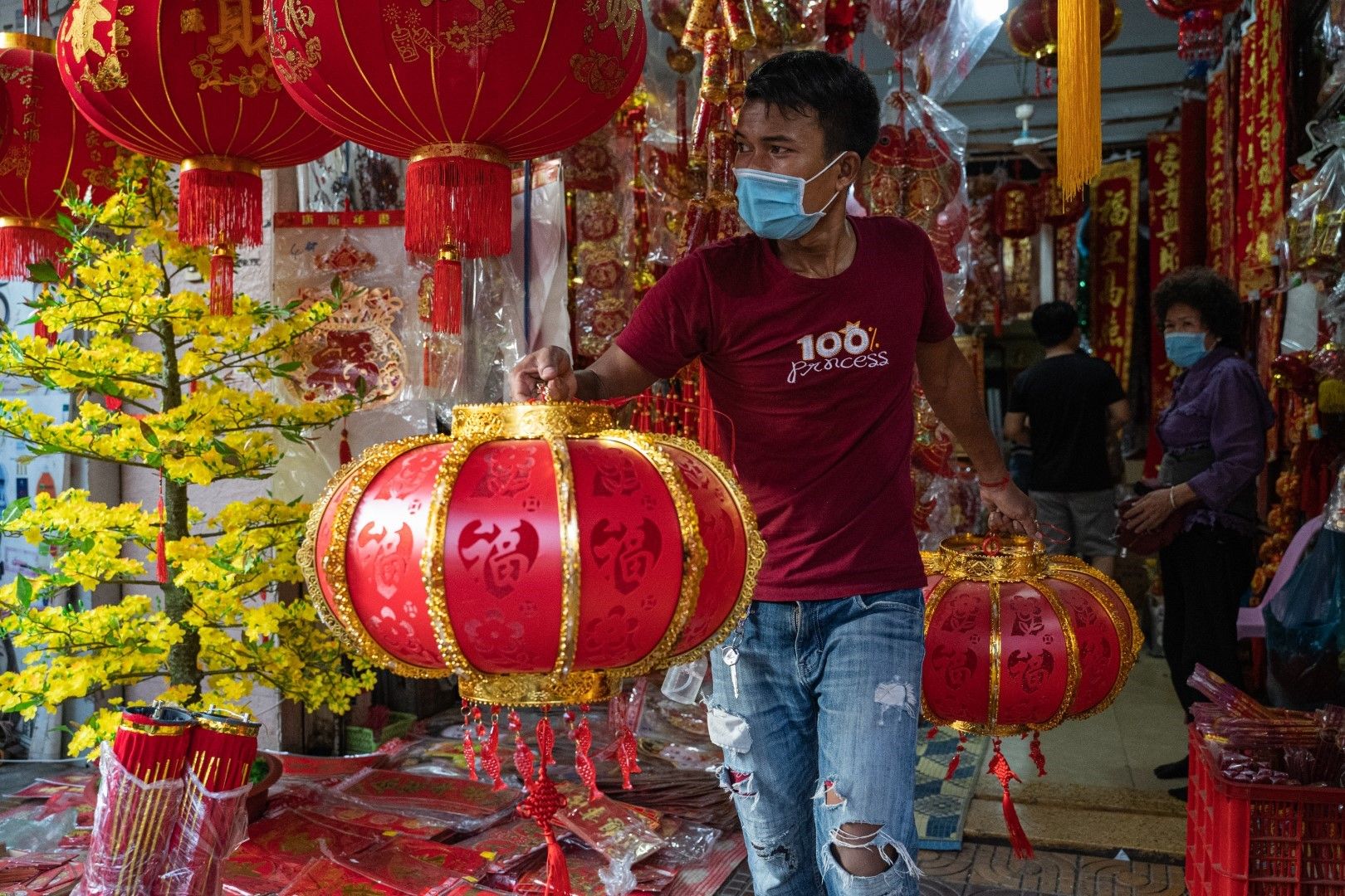 Уличен продавач предлага украшения за Китайската нова година в Камбоджа